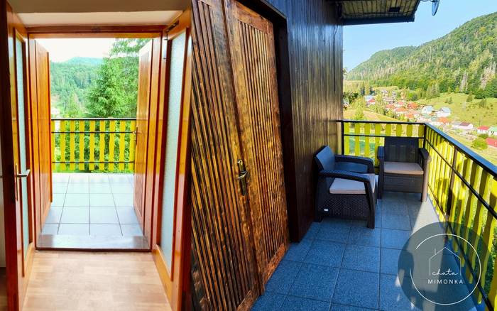 Balkón s posedením a výhľadom na okolitú obec a kopce