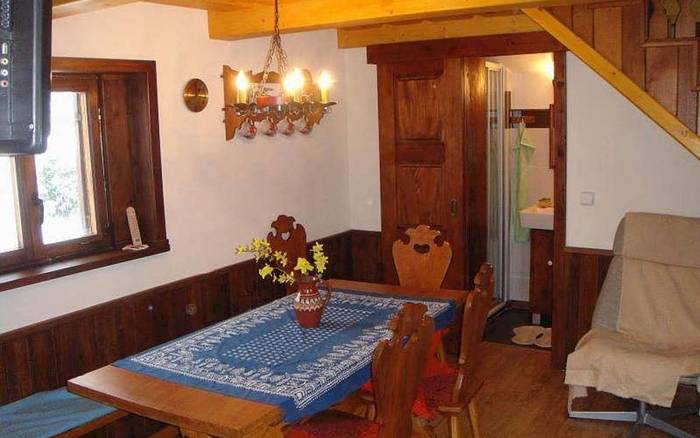 Společenská místnost s jídelním posezením a krbem