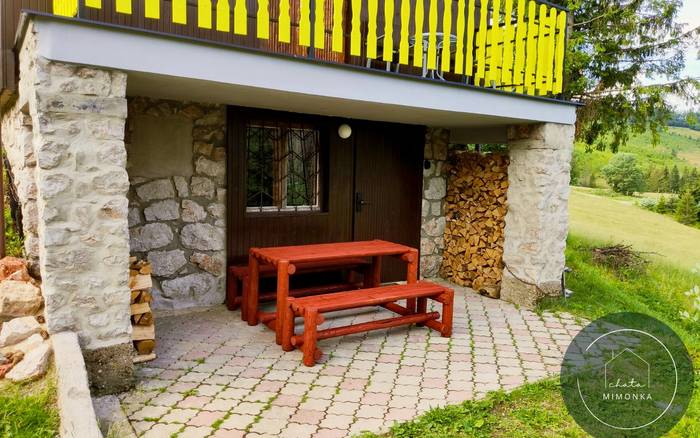 Kryté exteriérové posedenie s dreveným stolom a lavičkami