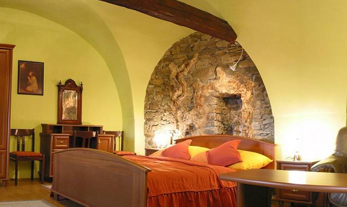Izba s kamennými stenami a krbom na drevo